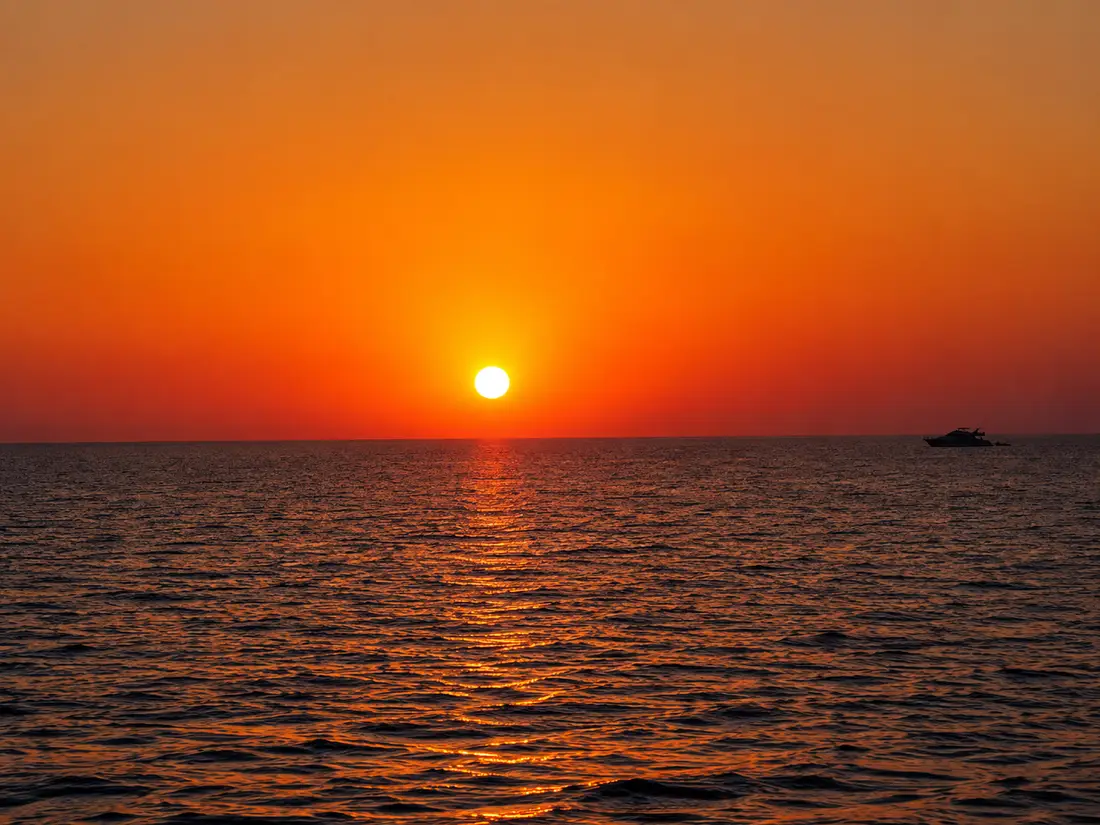 Sunset over the Red Sea with a boat on the horizon